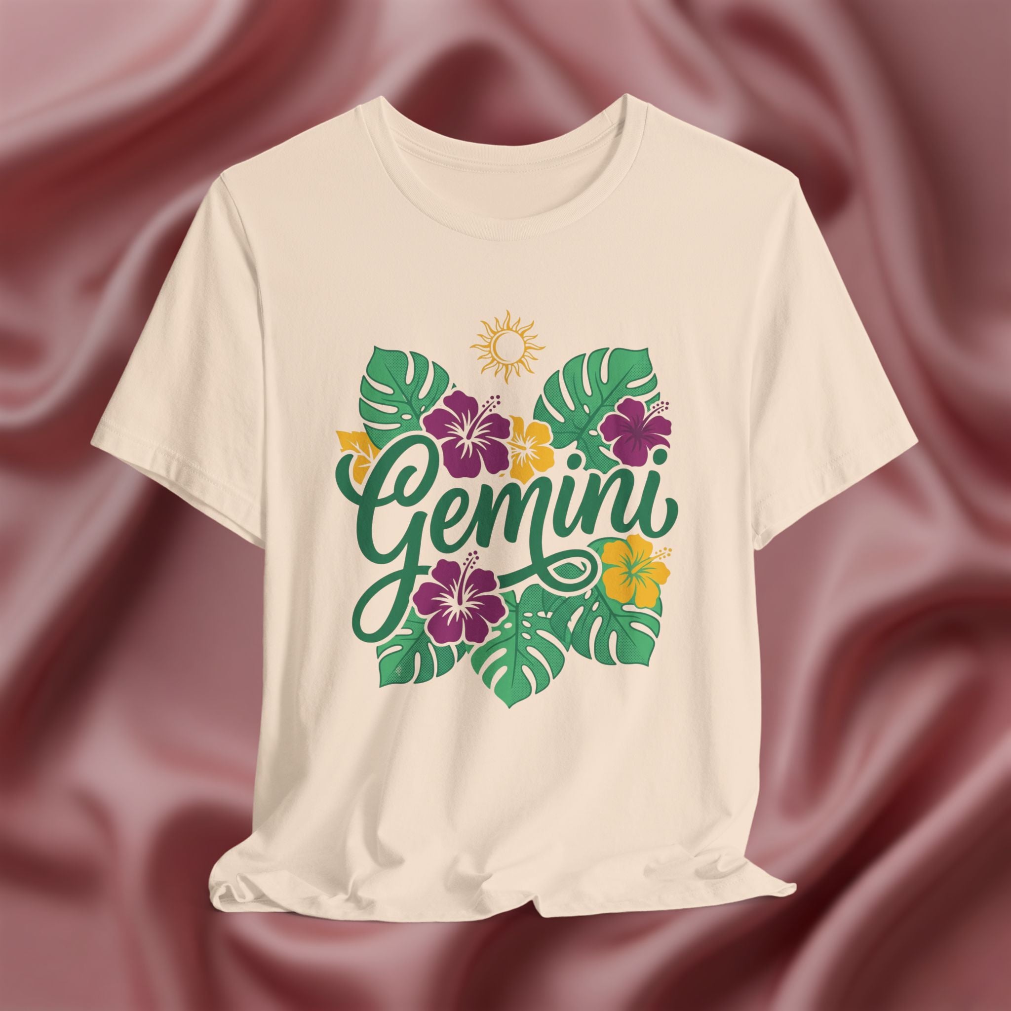 Beige t-shirt with 'Gemini' design featuring flowers and leaves on a maroon fabric background