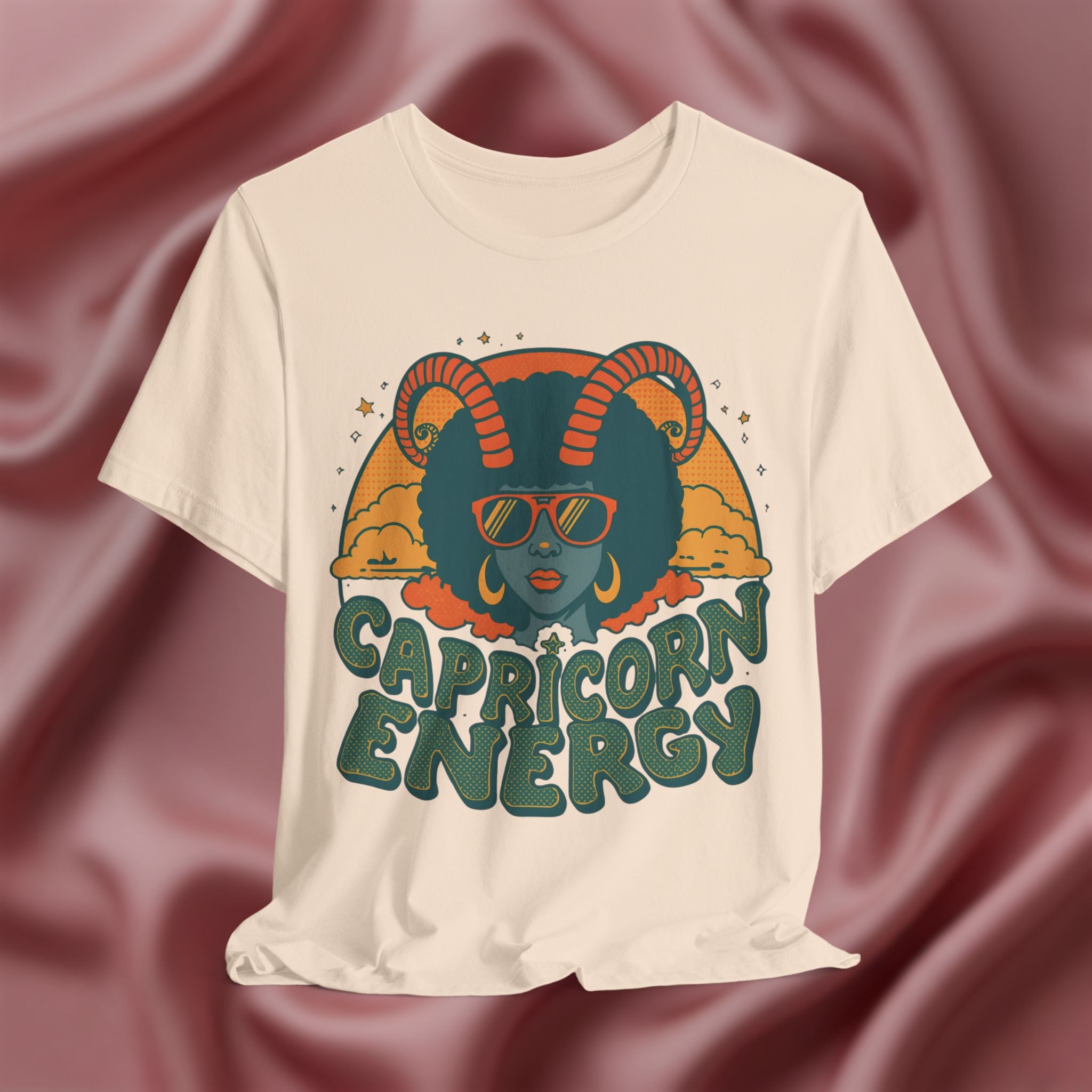 Soft cream T-shirt with Capricorn design and 'Capricorn Energy' text on a textured brown background