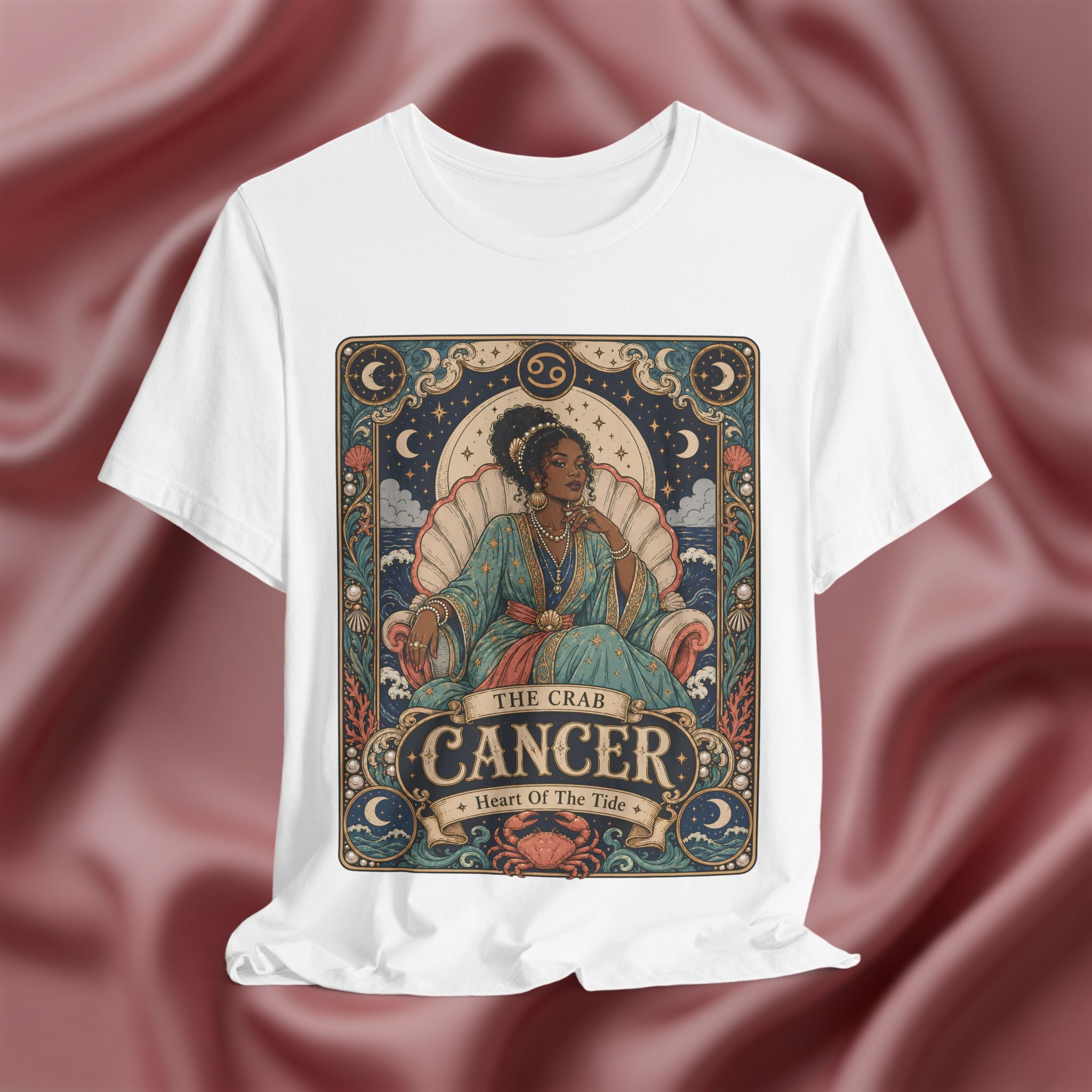 White t-shirt with Cancer zodiac design on a maroon fabric background