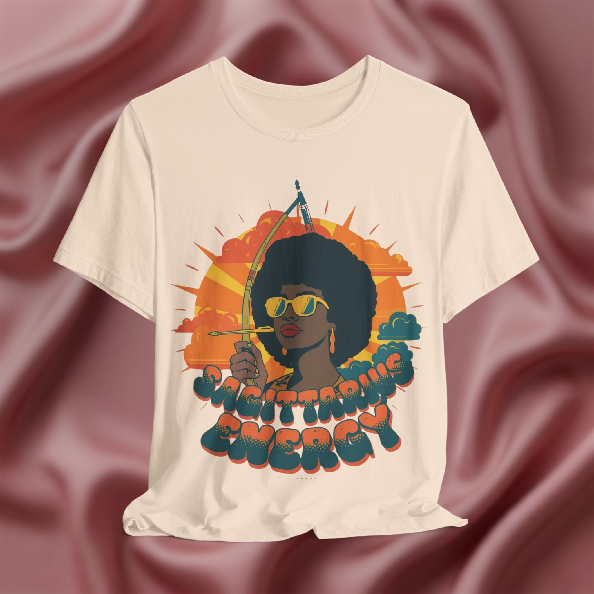 Cream T-shirt with a graphic of a woman holding an arrow and the text 'Sagittarius Energy'
