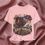 Pink t-shirt with Sagittarius zodiac design on a maroon fabric background