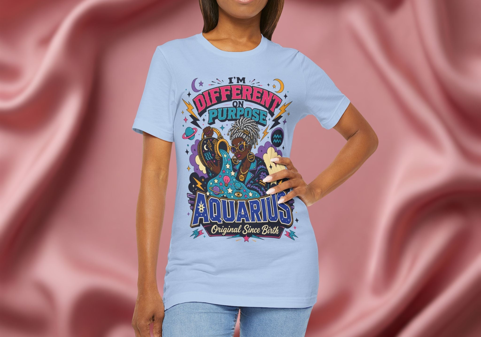 Person wearing a t-shirt with Aquarius design on a pink fabric background