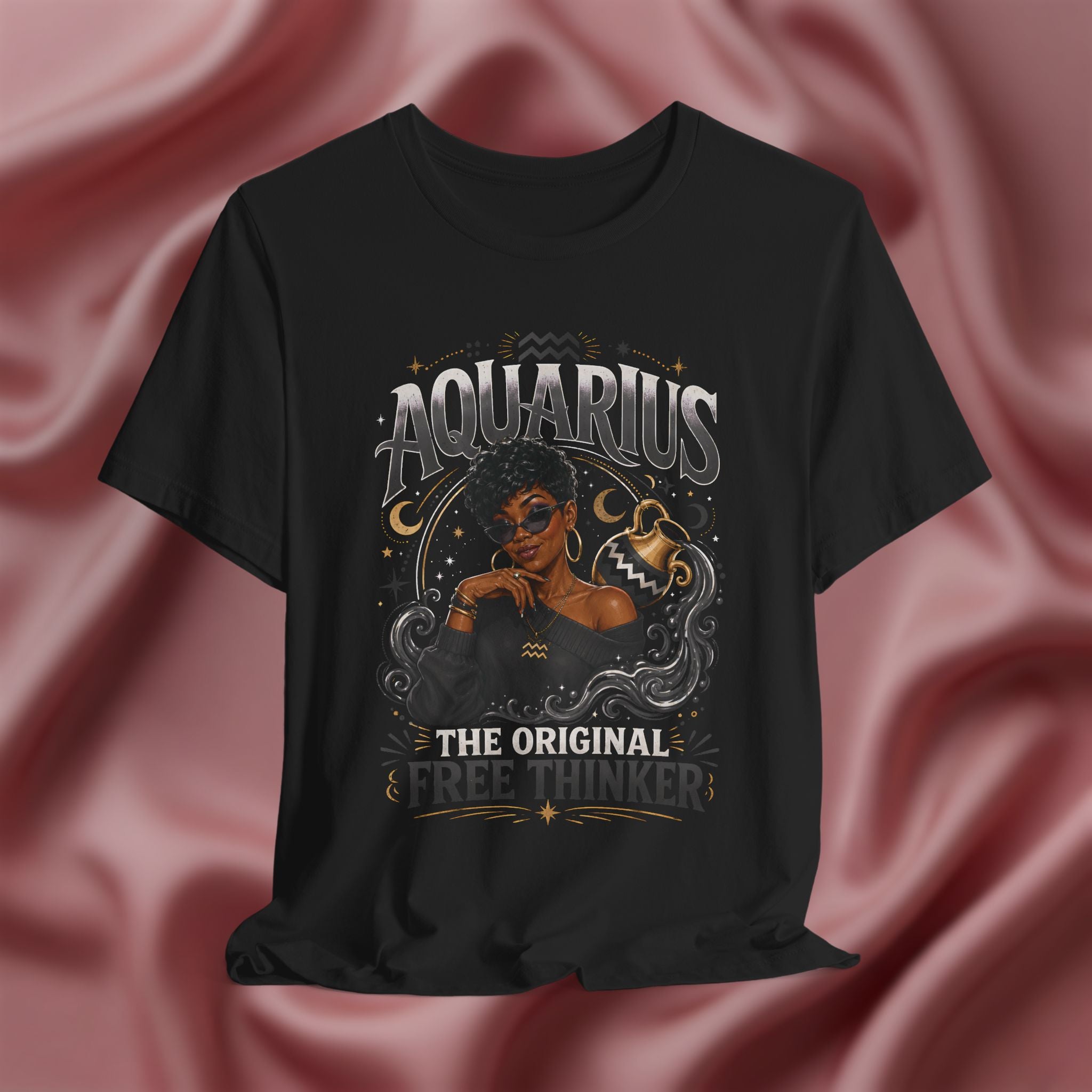 Black t-shirt with Aquarius design featuring a black woman and text 'The original free thinker' on a pink fabric background