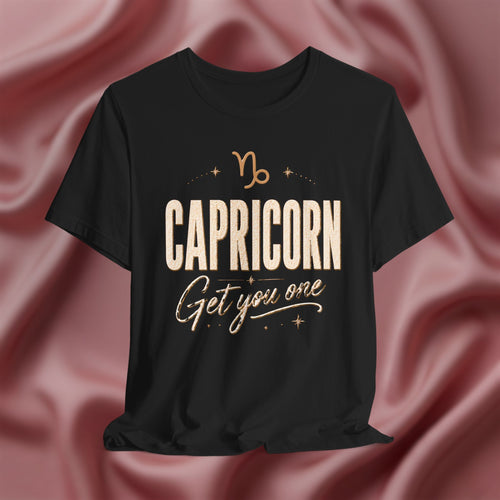 Black t-shirt with 'Capricorn Get you one' text on a pink fabric background