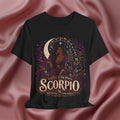 Black t-shirt with Scorpio zodiac design on a pink fabric background