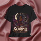 Black t-shirt with Scorpio zodiac design on a pink fabric background