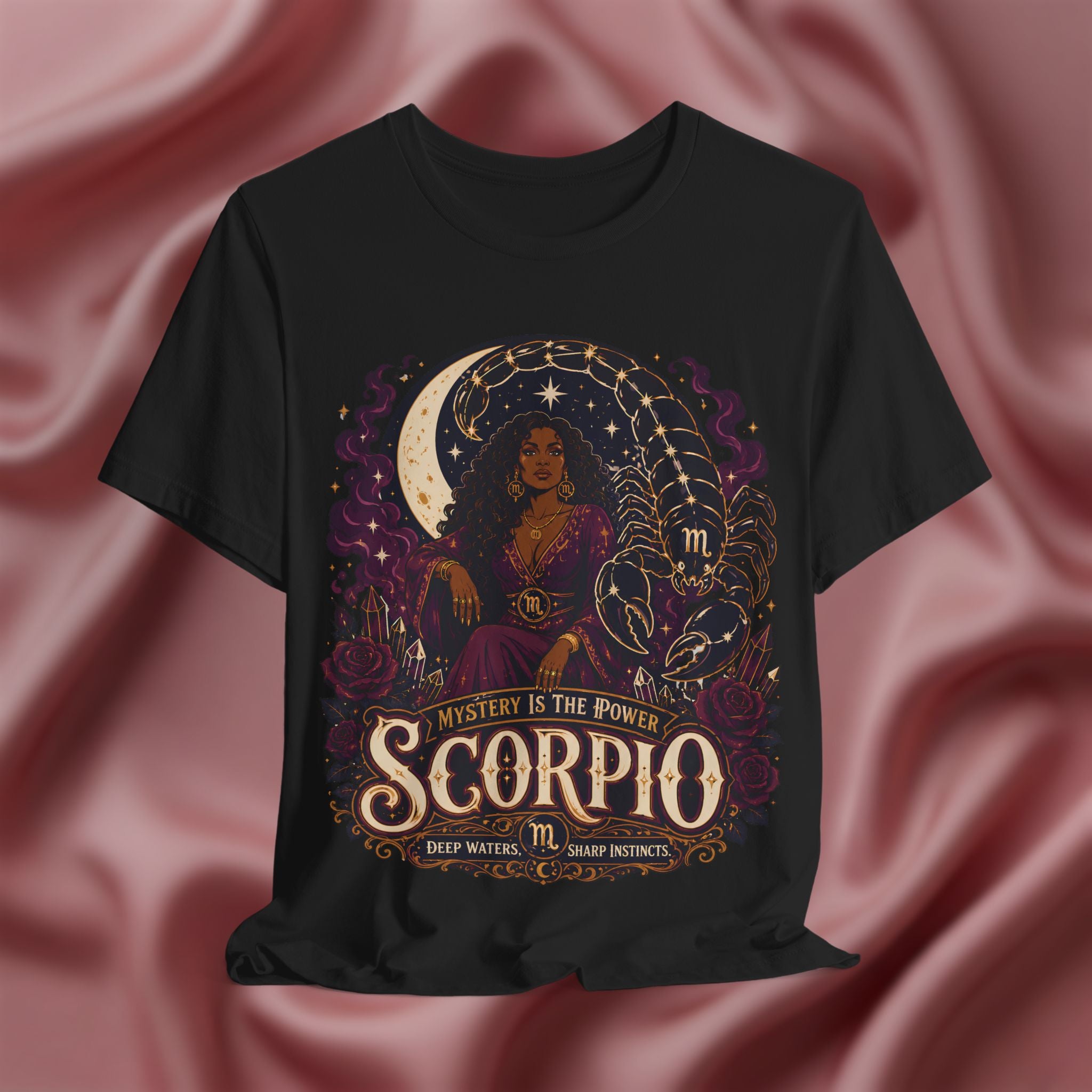 Black t-shirt with Scorpio zodiac design on a pink fabric background