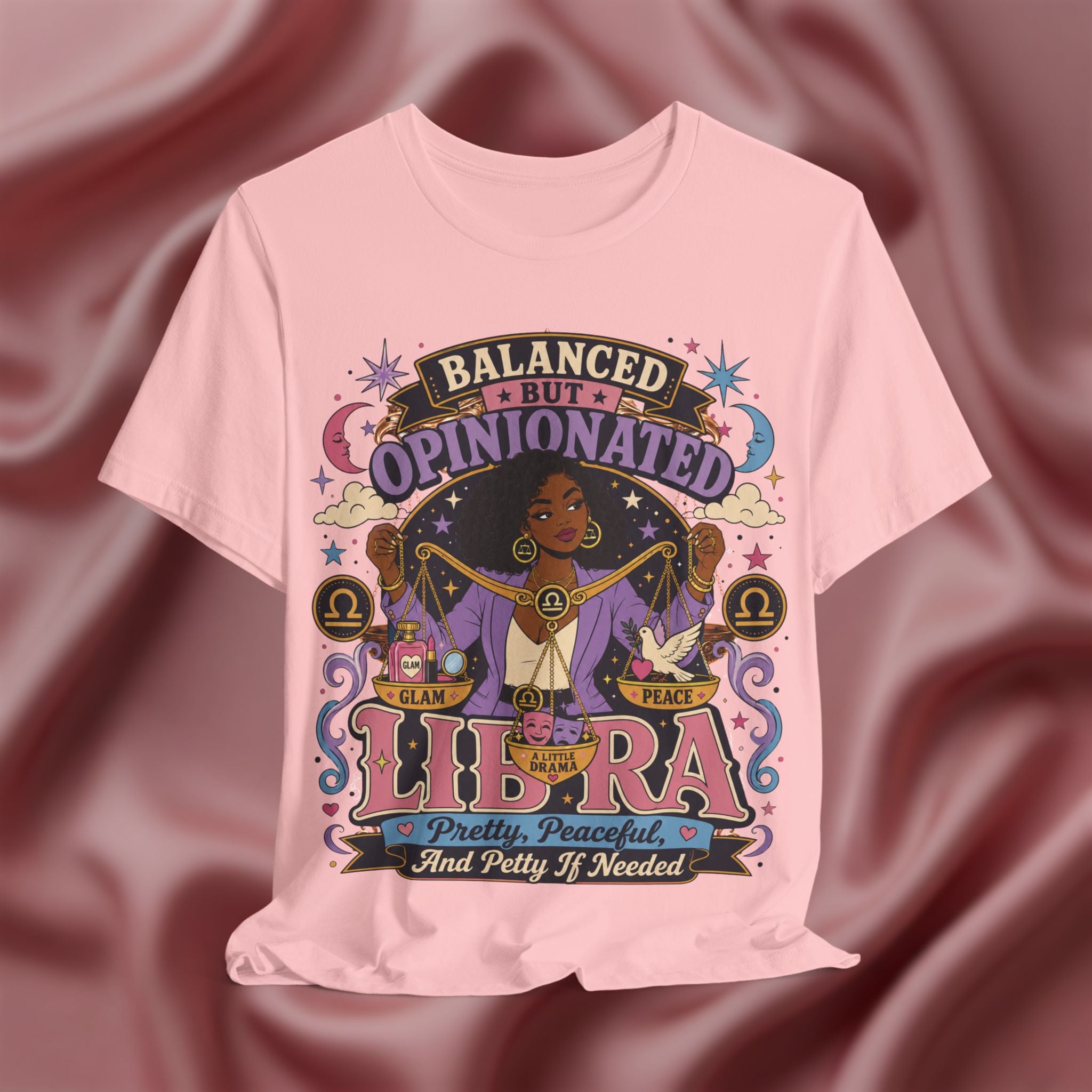 Pink t-shirt with Libra zodiac design on a maroon fabric background