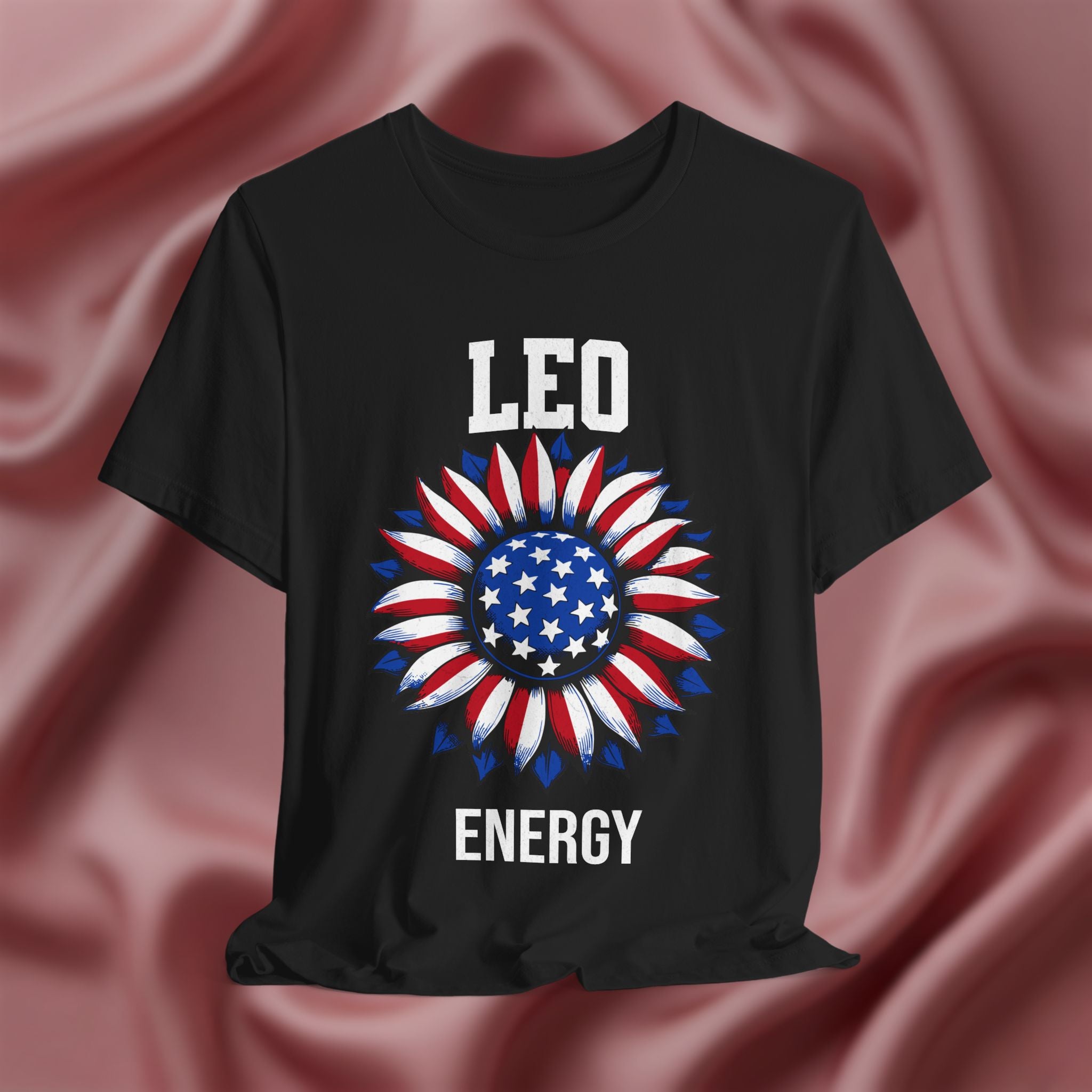 Black t-shirt with American flag sunflower and 'LEO ENERGY' text on a textured pink background