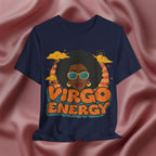 A navy blue graphic t-shirt featuring a retro-style illustration of a woman with an afro, sunglasses, and the text 'VIRGO ENERGY' in orange and teal, displayed against a draped pink satin background.