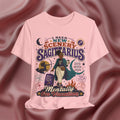 Pink t-shirt with Sagittarius zodiac design on a maroon fabric background