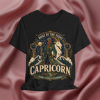 Black t-shirt with Capricorn zodiac design on a pink fabric background