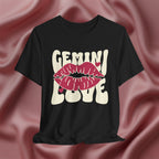 Black t-shirt with 'GEMINI Love' and lips design on a pink fabric background
