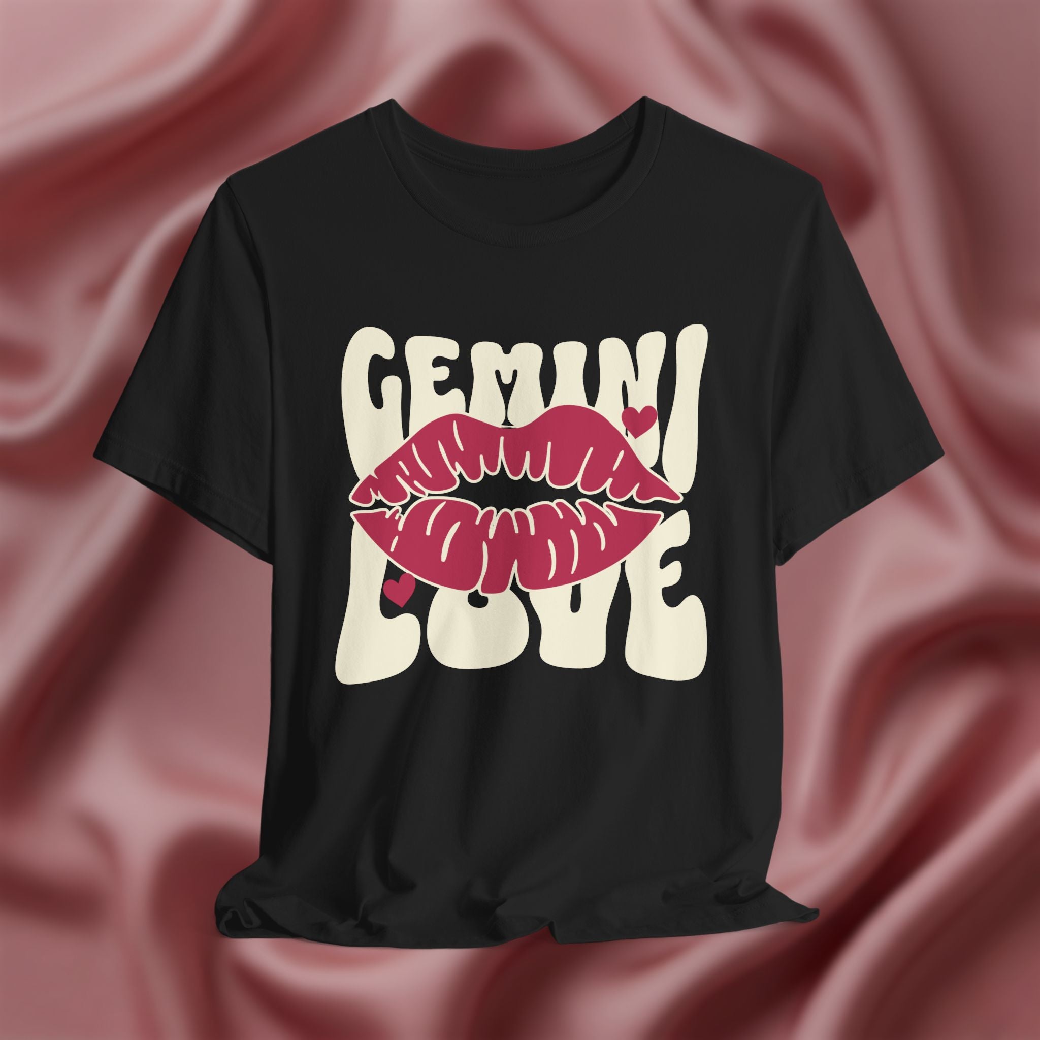 Black t-shirt with 'GEMINI Love' and lips design on a pink fabric background