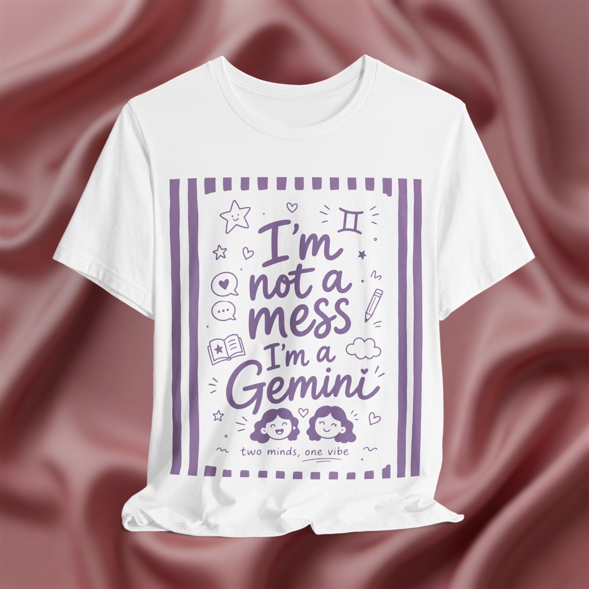 White t-shirt with purple text 'I'm not a mess I'm a Gemini and graphics on a pink fabric background