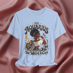 Light blue t-shirt with 'Aquarius Too Weird To Care' design featuring a black woman wearing a t-shirt with the text 'different is my superpower' on a pink fabric background