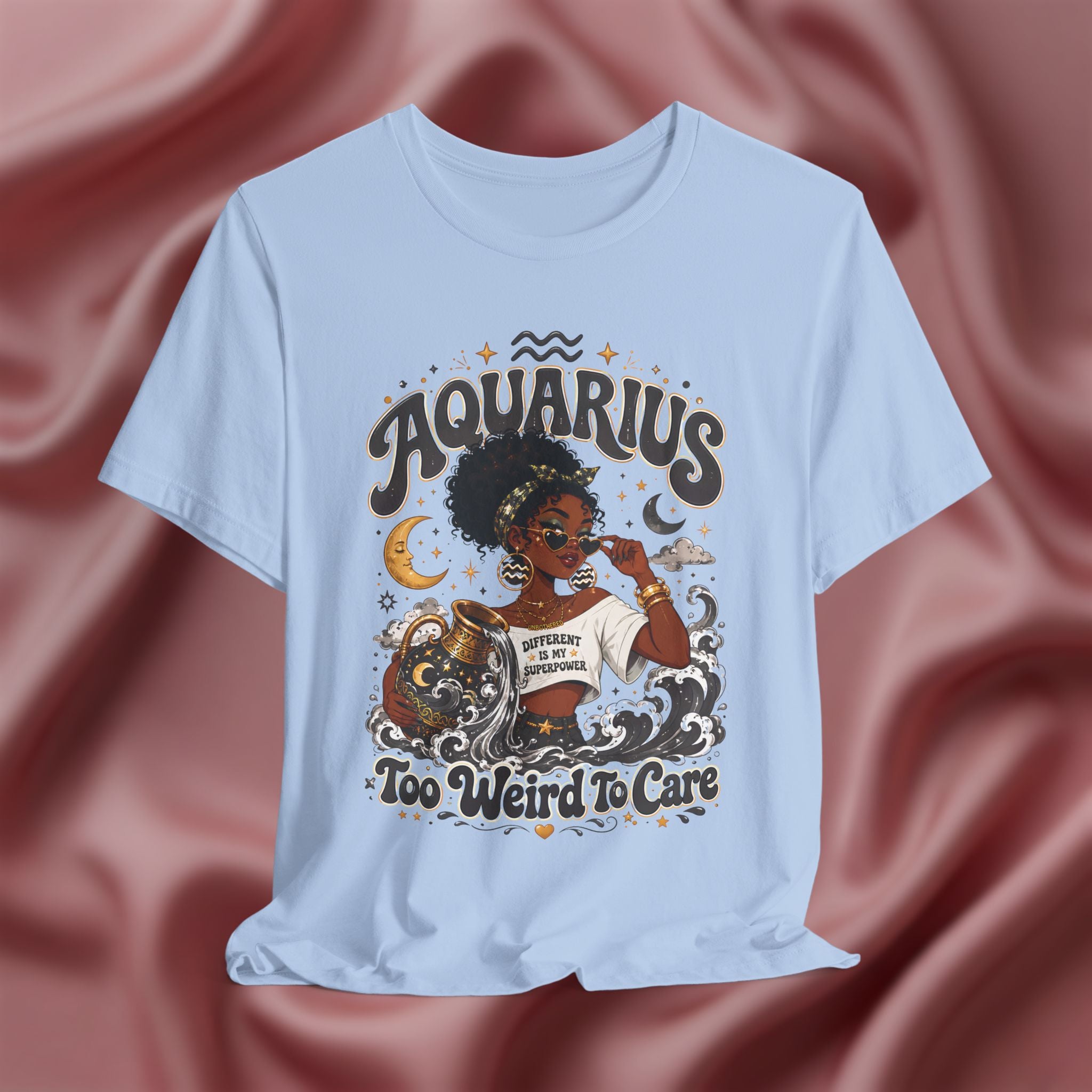 Light blue t-shirt with 'Aquarius Too Weird To Care' design featuring a black woman wearing a t-shirt with the text 'different is my superpower' on a pink fabric background