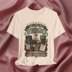 A soft cream short-sleeve t-shirt with a detailed graphic print featuring the text 'I DON'T NEED COFFEE VIRGO' and 'I NEED IT MADE CORRECTLY' with vintage coffee-themed illustrations, displayed against a draped maroon satin background.