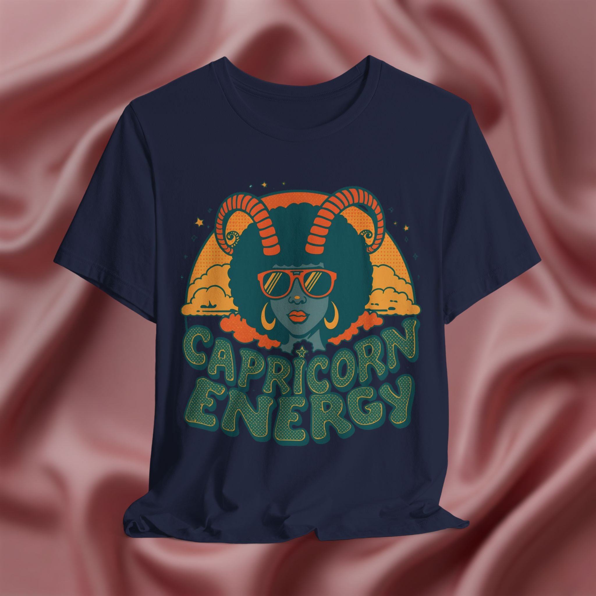 Navy blue t-shirt with Capricorn design and 'Capricorn Energy' text on a pink fabric background