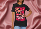Woman wearing a black t-shirt with colorful floral design and 'Rooted in Gemini' text on a pink fabric background