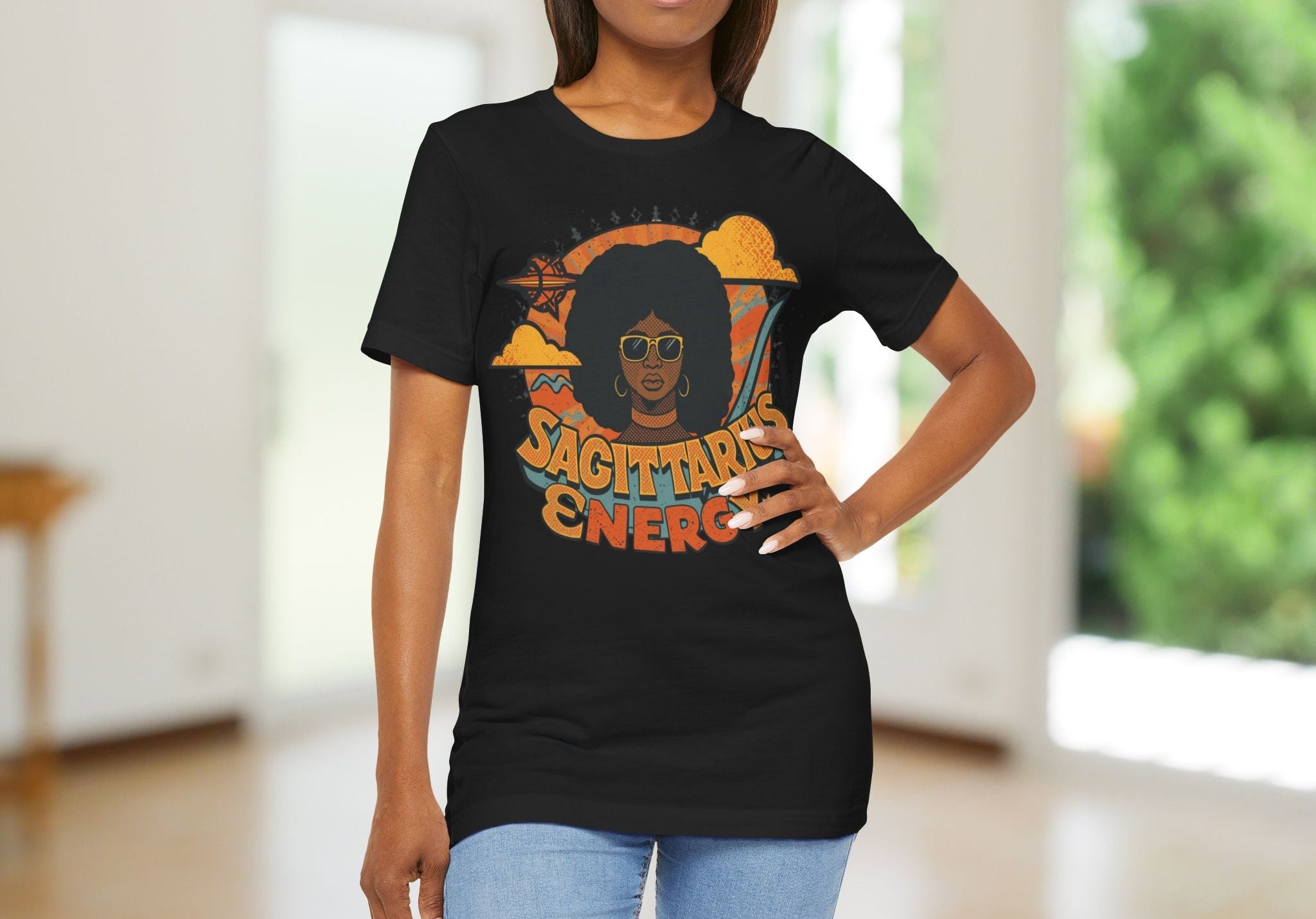 Woman wearing a black t-shirt with 'Sagittarius Energy' design on a pink fabric background