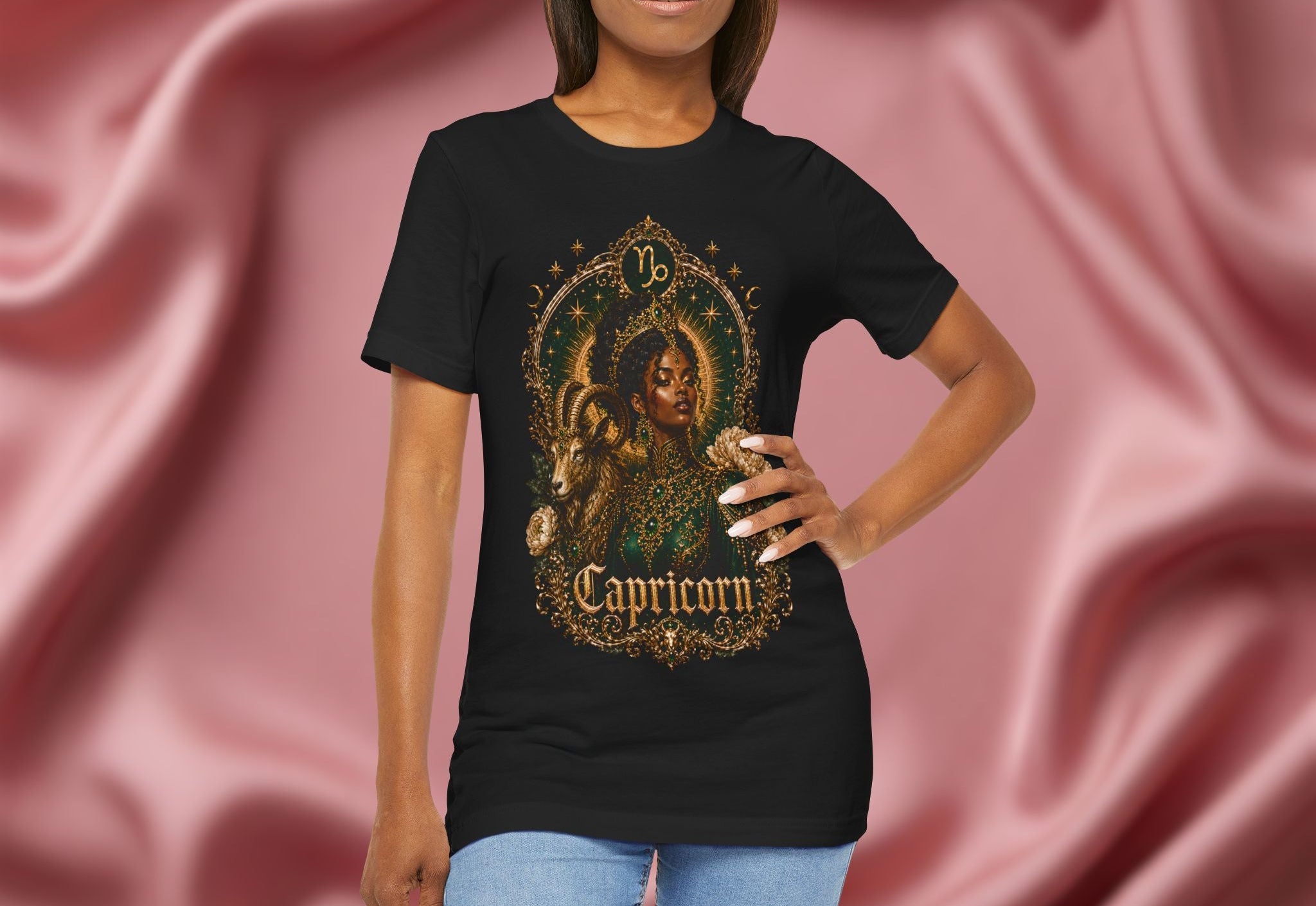Woman wearing a black t-shirt with Capricorn zodiac design against a pink fabric background