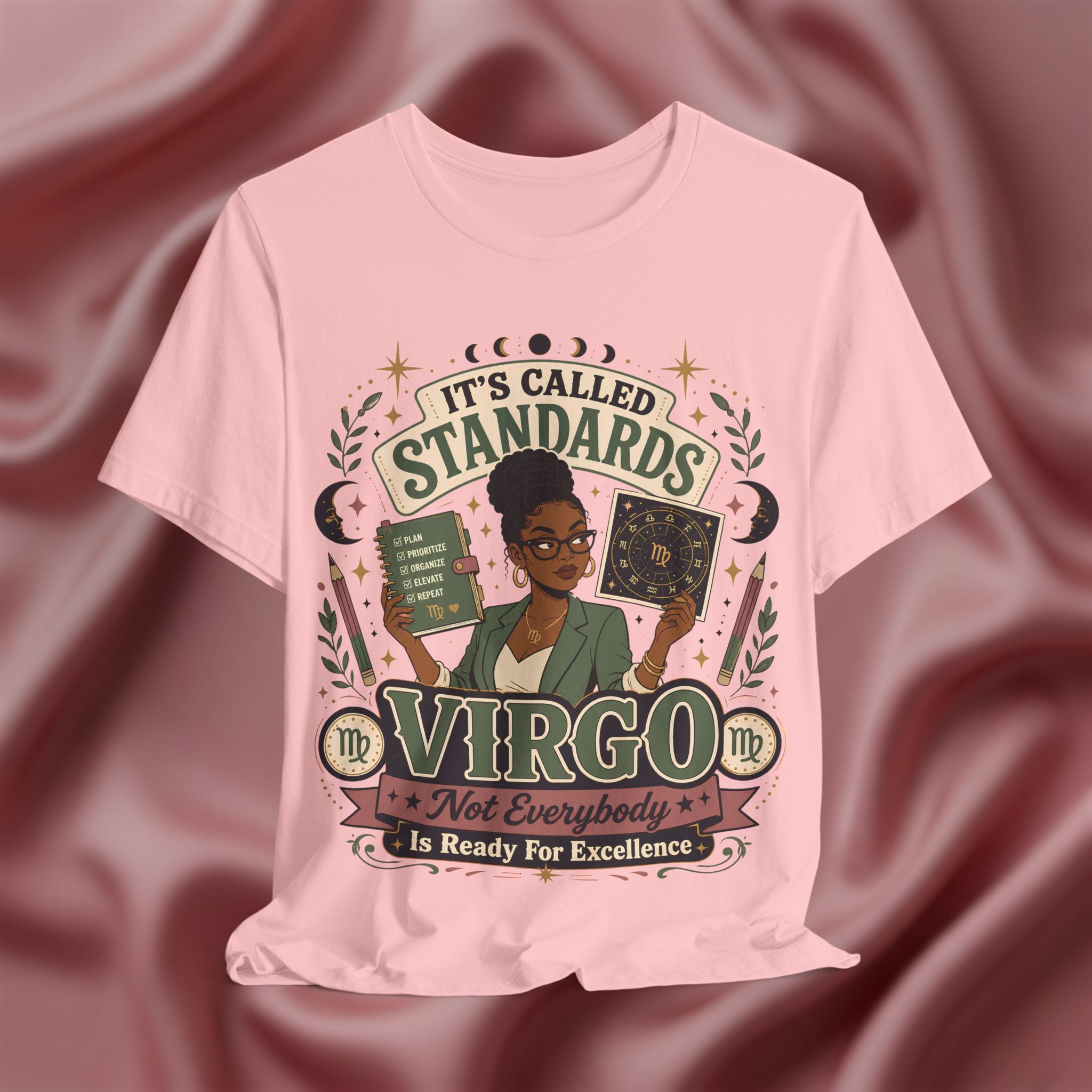 pink t-shirt with Virgo zodiac design on a maroon fabric background