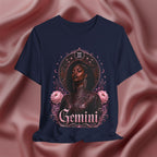 Navy blue t-shirt with a graphic design of a woman, flowers, and the word 'Gemini' on a pink fabric background.