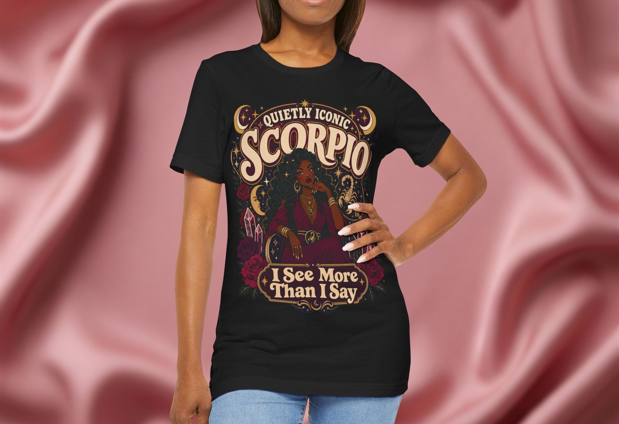 Woman wearing a black t-shirt with 'Scorpio' design against a pink fabric background