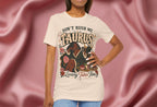 Woman wearing soft cream  a t-shirt with 'Don't Rush Me, Taurus, Luxury Takes Time' design against a pink fabric background