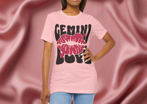 Person wearing a pink t-shirt with 'GEMINI' and lips design on a pink background