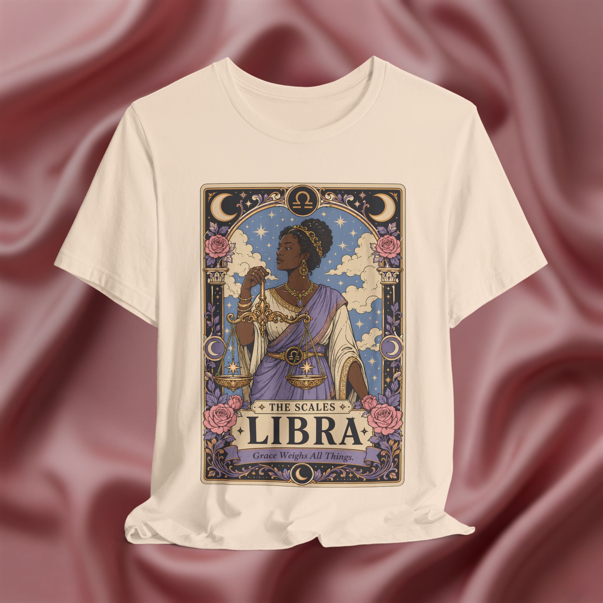 Soft cream T-shirt with Libra zodiac design on a textured red background