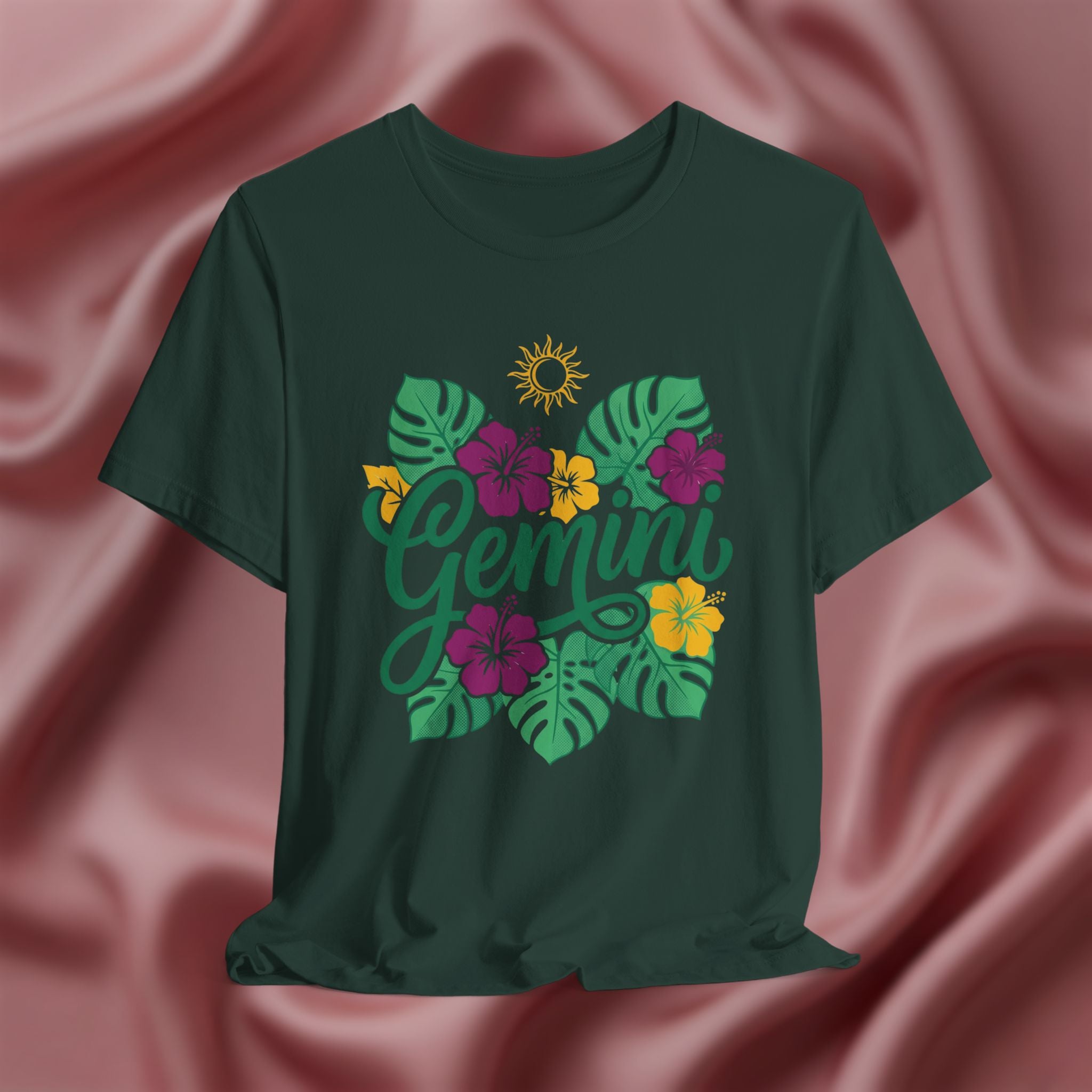 Green t-shirt with 'Gemini' design on a pink fabric background