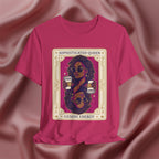 Sophisticated Queen Gemini Energy Pink t-shirt with a graphic design of a woman holding coffee cups on a pink fabric background