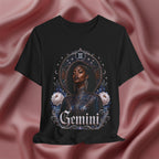 Black t-shirt with 'Gemini' design featuring a woman and astrological symbols on a pink fabric background.
