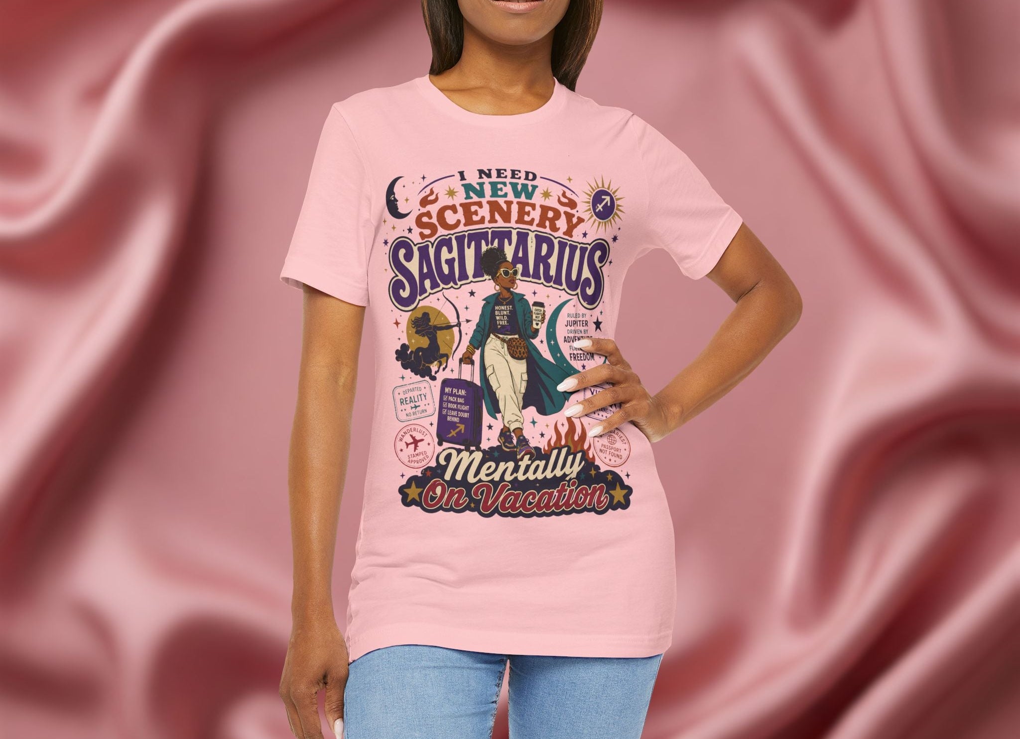 Person wearing a pink t-shirt with zodiac design against a pink fabric background