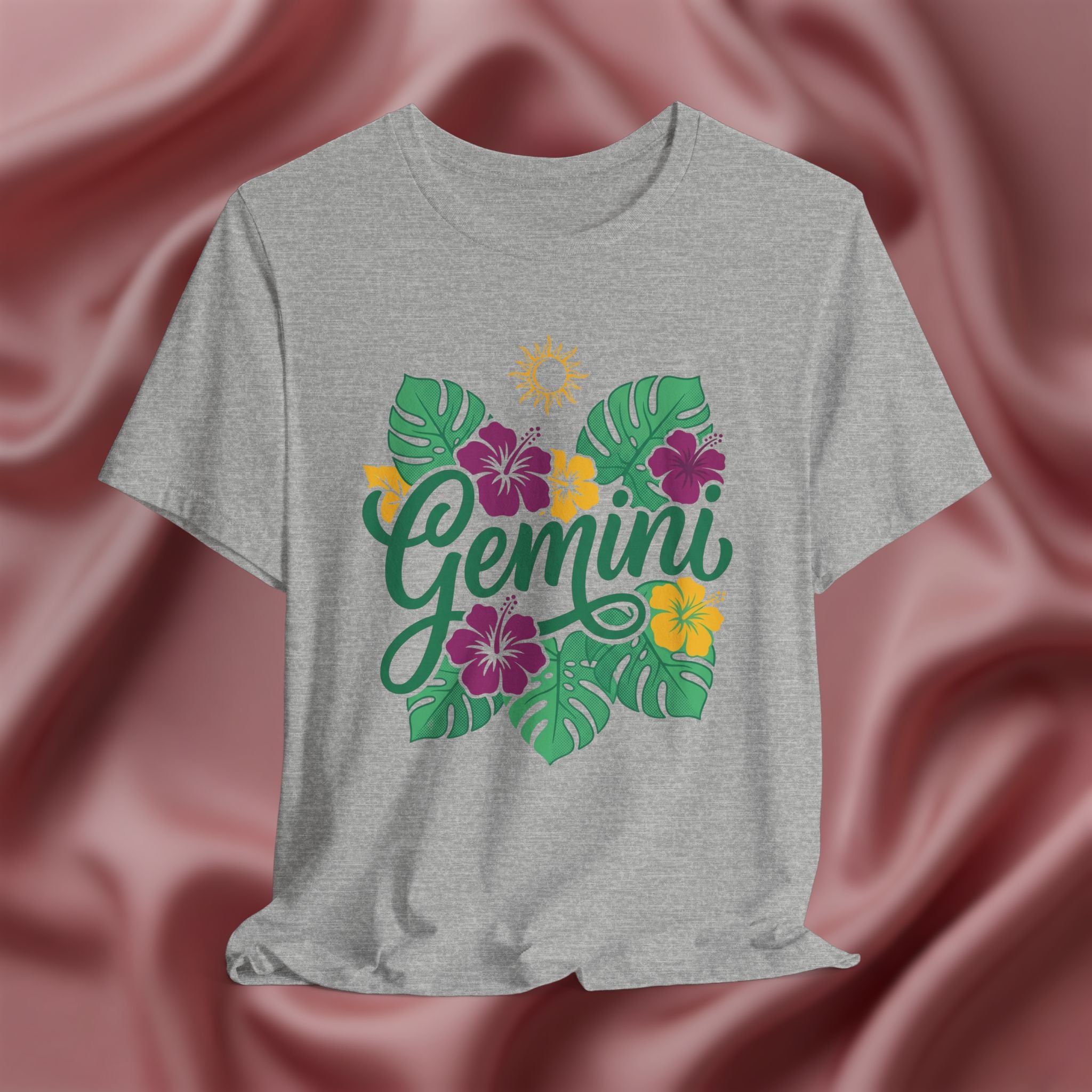Gray t-shirt with 'Gemini' design featuring flowers and leaves on a pink fabric background