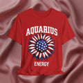 Red t-shirt with American flag sunflower and 'AQUARIUS ENERGY' text on a textured pink background