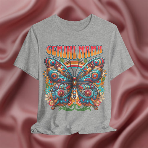 Gray t-shirt with a colorful butterfly design and 'Gemini Mama' text on a pink fabric background