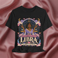 Black t-shirt with Libra zodiac design on a pink fabric background