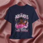Navy blue t-shirt with Aquarius design featuring a black woman and text 'The original free thinker' on a pink fabric background