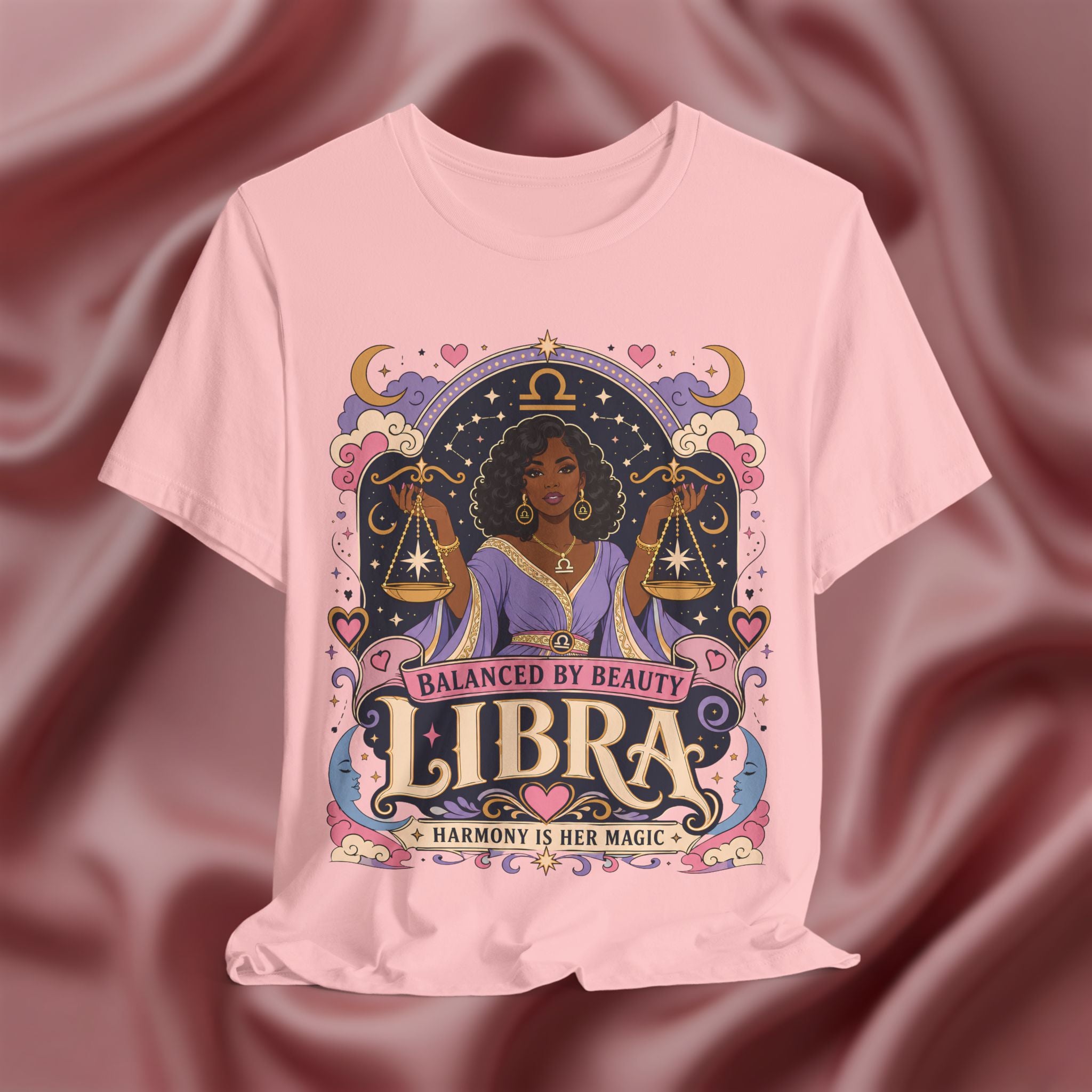 Pink t-shirt with Libra zodiac design on a maroon fabric background