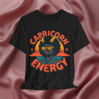 Black t-shirt with 'Capricorn Energy' design on a pink fabric background