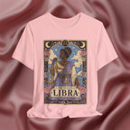 Pink t-shirt with Libra zodiac design on a maroon fabric background