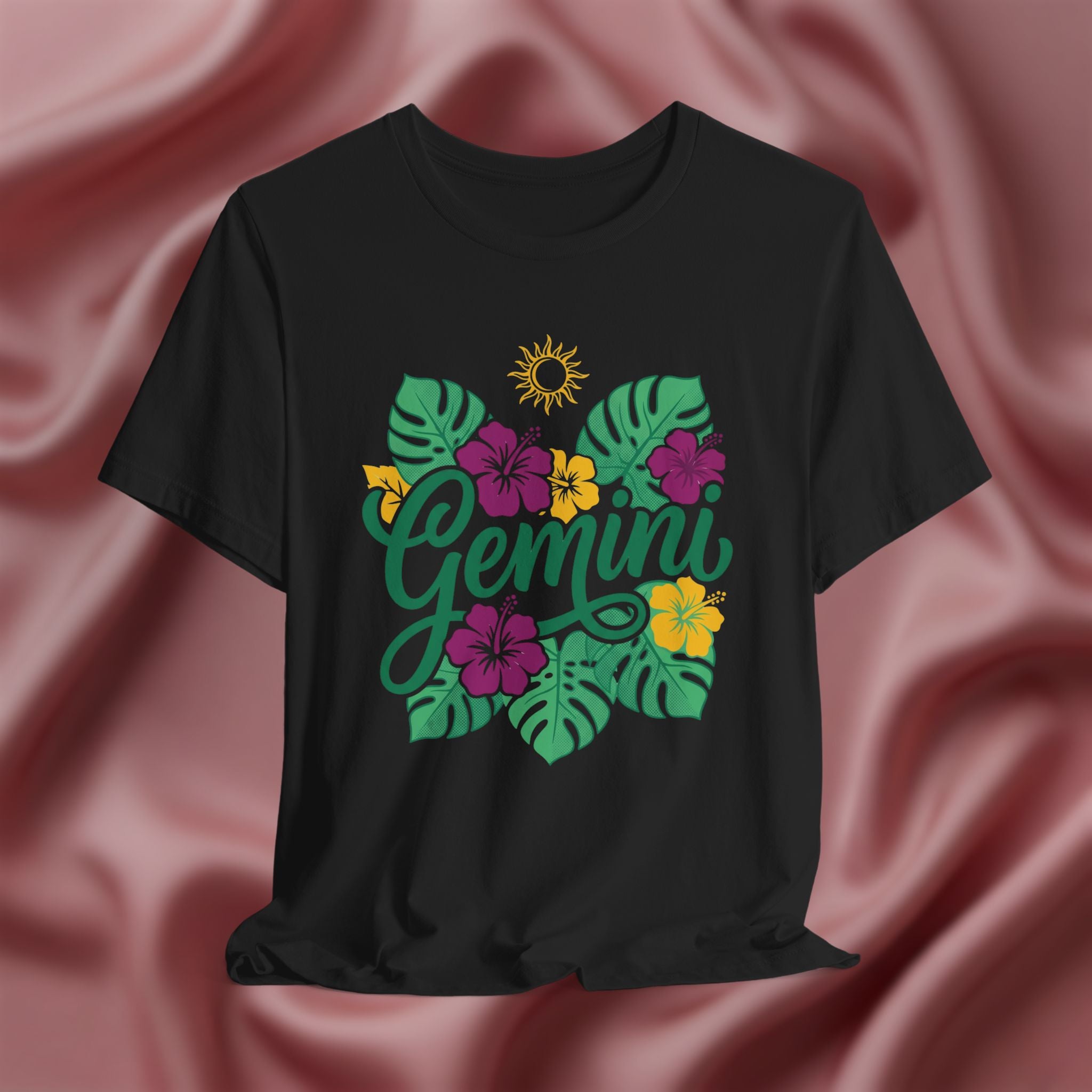 Black t-shirt with 'Gemini' design featuring flowers and leaves on a pink fabric background