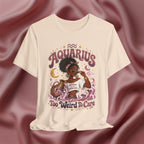 Beige t-shirt with 'Aquarius Too Weird To Care' design featuring a black woman wearing a t-shirt with the text 'different is my superpower' on a pink fabric background