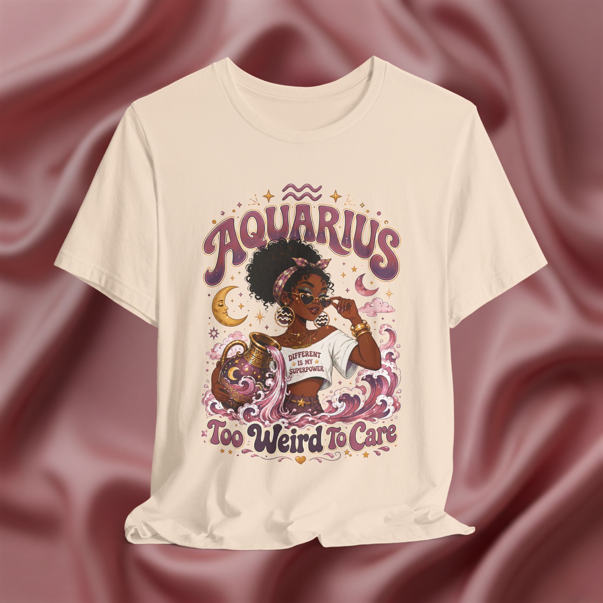 Beige t-shirt with 'Aquarius Too Weird To Care' design featuring a black woman wearing a t-shirt with the text 'different is my superpower' on a pink fabric background