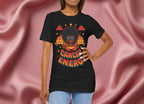 Woman wearing a black t-shirt with a graphic design of a person with an afro and 'Cancer Energy' text on a pink fabric background.