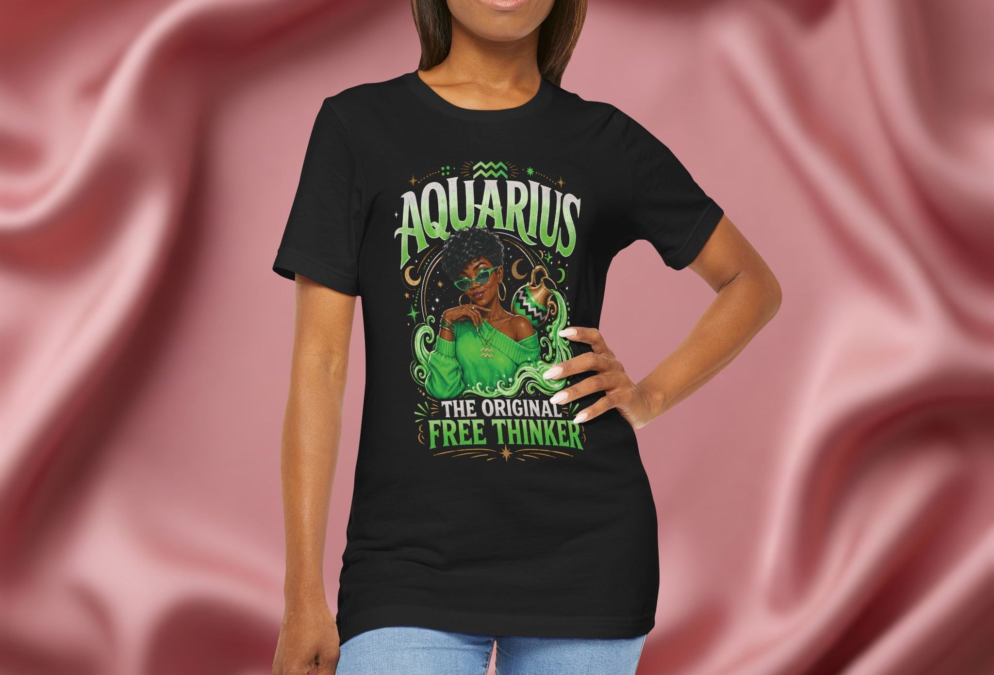 Person wearing a black t-shirt Pink t-shirt with Aquarius design featuring a black woman and text 'The original free thinker' on a pink fabric background