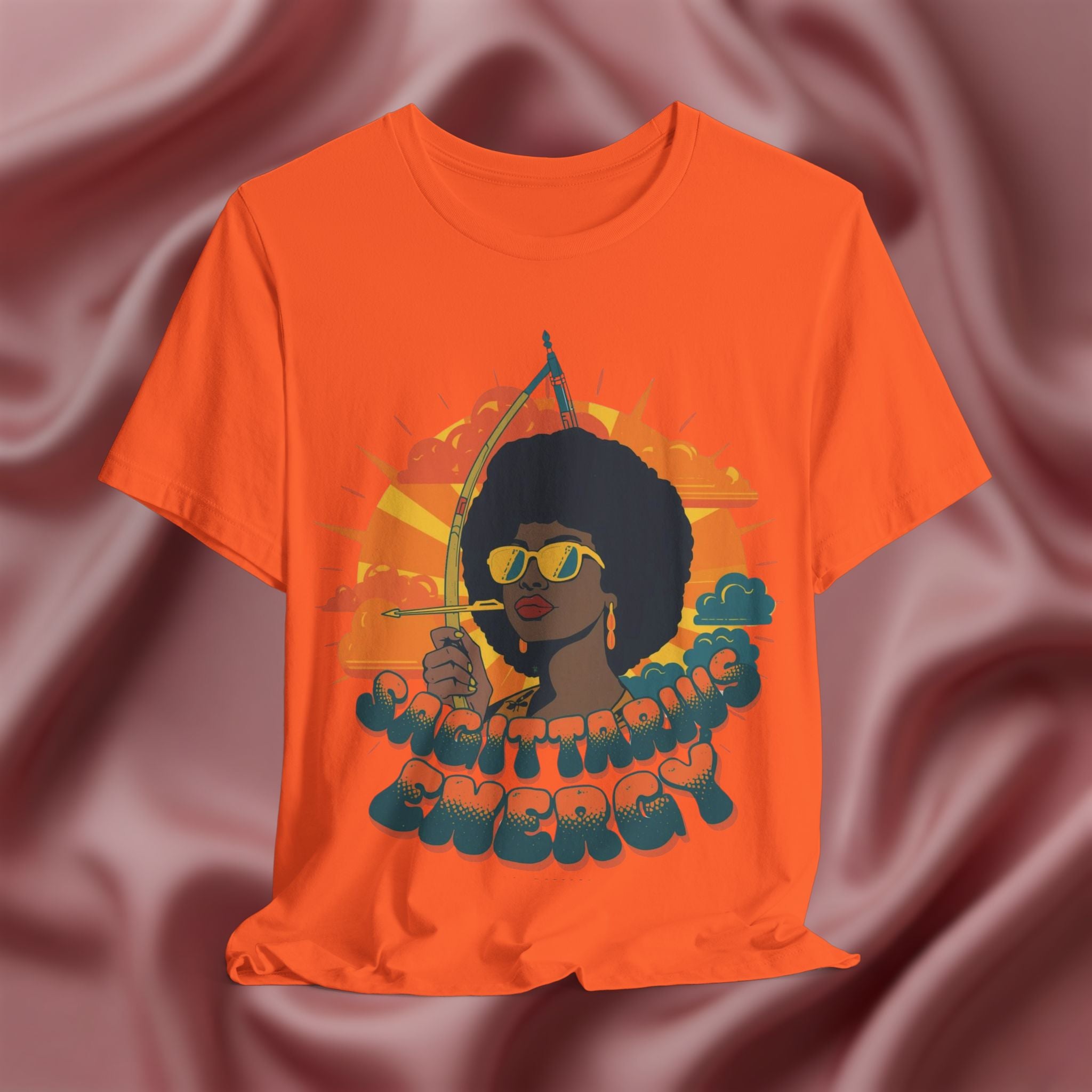 Orange t-shirt with a graphic of a woman holding an arrow and the text 'Sagittarius Energy'